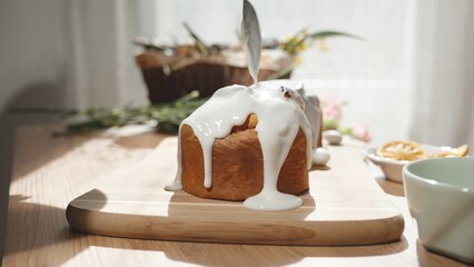 A Woman Frosting a Traditional Easter Cake with White Cream. Homemade Baking, Sunlight Streaming in Through the Window.