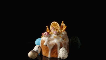 Easter Cake with Eggs on a Black Background Decorated with Dried Orange Slices and Rose Flowers.