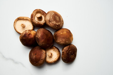 Raw Shiitake mushrooms on white marble background