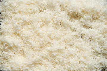 Grated parmesan cheese on a wooden board. White, bright and clean background.