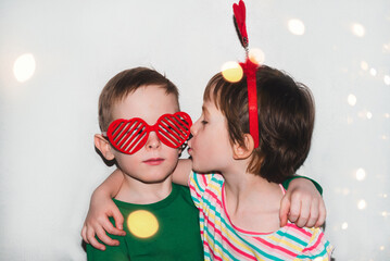 Couple of children are having fun hugging. Boy and girl wearing accessories for Valentine's day. Holiday and fun concept.