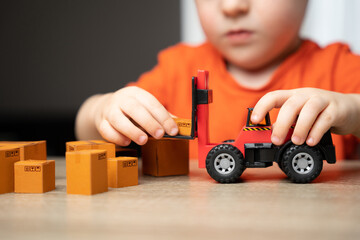 A child plays in loading boxes with a toy forklift. Warehouses, manufacturing facilities, and...