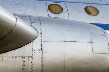 part of the plane with portholes and a turbine