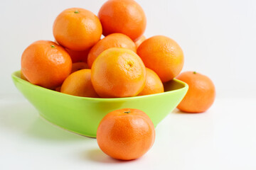 Close up. Tangerines on white background and green porcelain plate. 