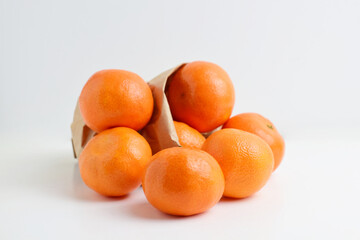 Close up, group of tangerines in kraft paper bag.