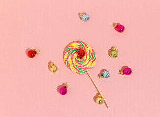 Minimal idea colorful lollipop and Christmas balls. Pattern scene on pink background.