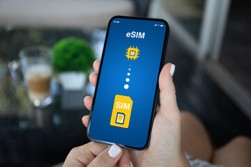 Woman hand hold phone with Sim card replacement on eSim