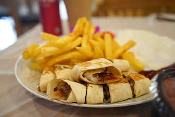 Chicken shawarma the traditional Middle Eastern dish serving with French fried in Jordan..
