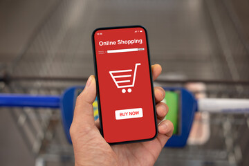 male hand hold phone app online shopping over shopping cart
