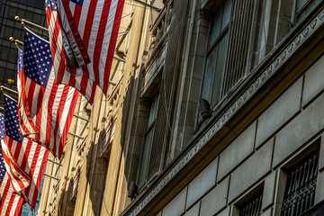 American flags waving on the skyscrapers of Fifth Avenue, in the heart of Manhattan and the heart...