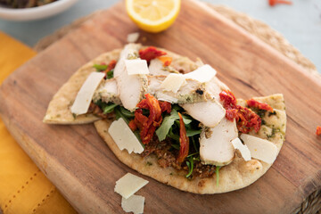 Flatbread with chicken greens, sun-dried, tomatoes, and pesto