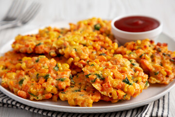 Homemade Carrot Corn Fritters with Ketchup on a Plate, low angle view. Close-up.