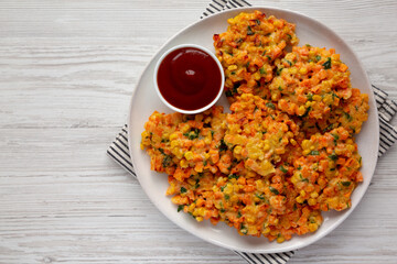 Homemade Carrot Corn Fritters with Ketchup on a Plate, top view. Flat lay, overhead, from above.
