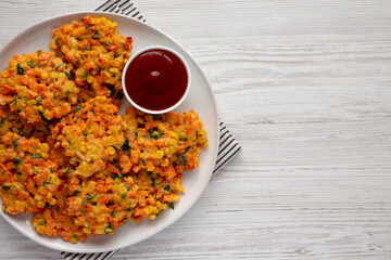 Homemade Carrot Corn Fritters with Ketchup on a Plate, top view. Flat lay, overhead, from above. Copy space.