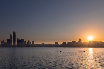Fototapeta na wymiar sunrise overlooking city scape, people relaxing in the capital city of Abu Dhabi