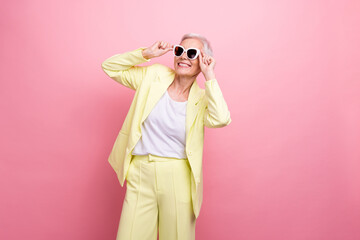 Photo of fashionista businesswoman wear yellow suit touching sunglasses look novelty accessories boutique isolated on pink color background