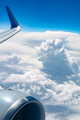 Flight above the clouds with a view of the left turbine, the wingtip and the cumulus clouds below - 5351