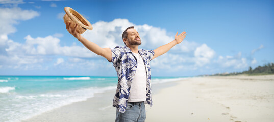 Happy young man enjoying the sea breeze on a beach
