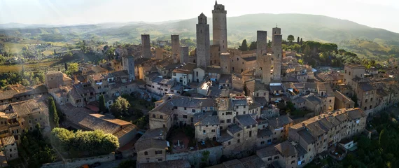 Poster San Gimignano - one of the most beautiful medieval towns in Tuscany, Italy. aerial drone view of the towers in the morning light . Unesco heritage site.. © Freesurf