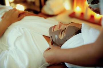 Serene ambiance of spa salon, woman customer indulges in rejuvenating with charcoal face cream...