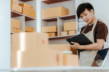SME small business entrepreneur, young Asian freelancer working at home with boxes Use smartphones and laptops for commercial monitoring, marketing, packaging, online sales.