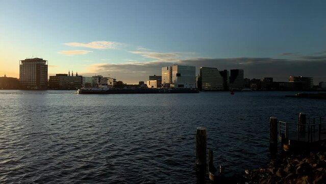 Skyline with modern buildings at river IJ at sunset in Amsterdam