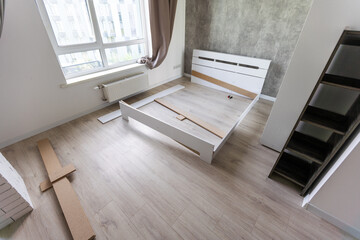 The furniture assembler assembles the bed frame, do it yourself and assemble new furniture