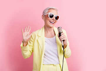 Portrait of positive mature age funny woman singing new hit soundtrack having fun in karaoke party...