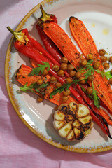 Healthy Homemade Roasted Carrots Ready to Eat with yougurt sause, vegan, vegatarian homemade food on pink backround.