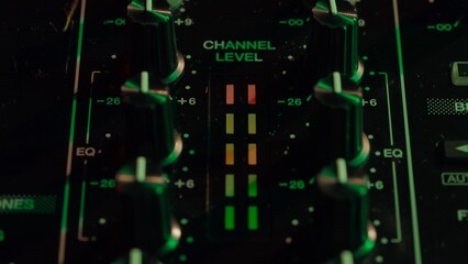 Close-up of DJ Mixing Board in Neon Club Lights