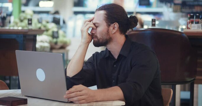 Job burnout male freelancer feels long-term debilitating stress, which can arise from work at laptop overload and fatigue. Concentrated man is frustrated by unsolved problems Job burnout concept