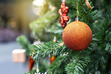 Christmas and New Year concept holiday background. Close up of sparkle light red ball decorate the Christmas tree.