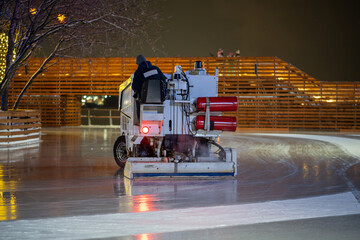 Ice preparation at rink. Ice rink resurfacer vehicle resurface machine outdoor between session....