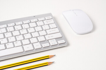 View of keyboard and mouse of a modern computer with pencils.