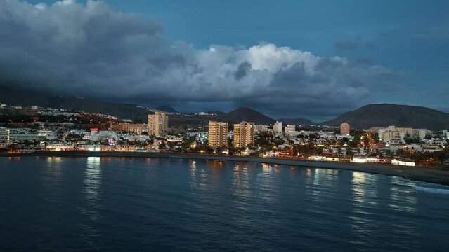 Veduta dal mare della costa di Tenerife al crepuscolo, nubi nel cielo e luci sulla citt&agrave;: Parte 3