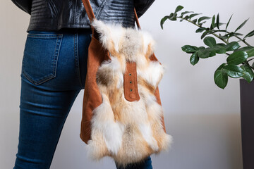 Fashionable fur handbag on a woman. Winter fashion background.