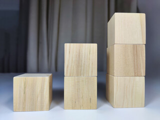 Small wooden cubes in columns, lined up in row. The concept of progressive movement in achieving the goal. Steps and stages of project development and implementation