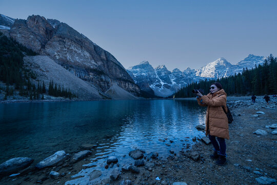 Female tourist carries a backpack, travels, walks, the beauty of the reflection in the water of moraine Lake, Canadian Rocky Mountains