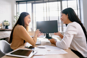 Two female accountants have a team meeting to summarize financial information in the office