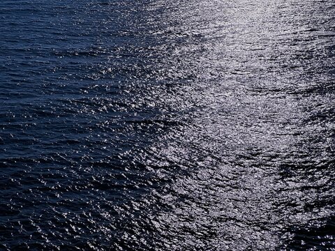 Dark blue glittering sea water surface at night. 