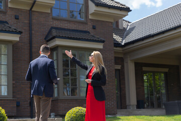 Blonde businesswoman inspects house with manager realtor support. Potential client listens to real...