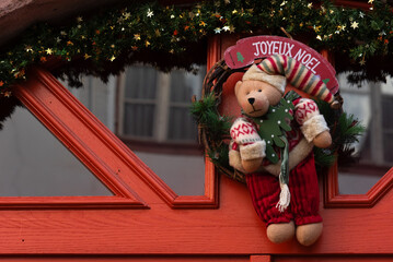 Alsace, France. Christmas wreath decoration on house door with teddy bear  holding Christmas tree. "Joyeux Noel" greeting ("Merry Christmas" in French). Christmas holiday celebration background. 