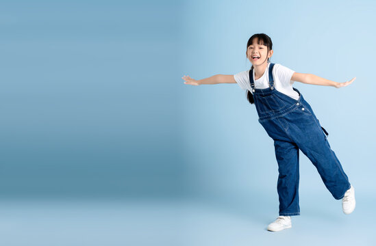 Full body image of an Asian girl posing on a blue background