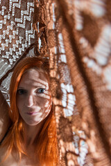 Portrait of beauty young redhead woman in lace brown fabric