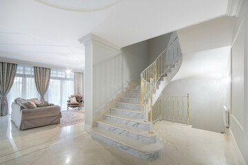 A hall with a marble staircase and gilded railings in a luxurious mansion. Living room .with...
