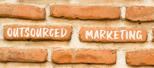 Outsourced marketing symbol. Concept words Outsourced marketing on beautiful brown brick wall. Beautiful brown brick wall background. Business Outsourced marketing concept. Copy space.