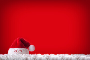 Happy new Year 2024 background with red Santa Hat on white snow.