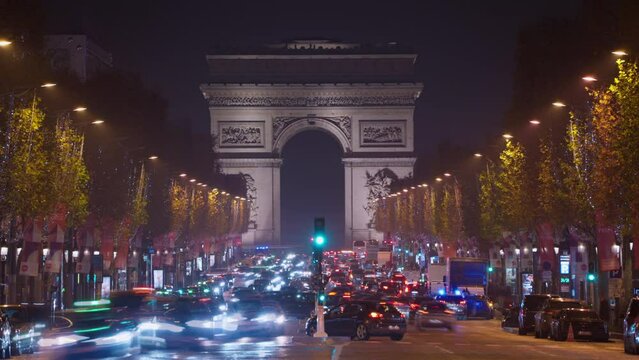 Triumphal arch in the evening on the Champs-Elysees in Paris. Time lapse of centre of Paris. Car traffic on a roundabout. Night city lights
