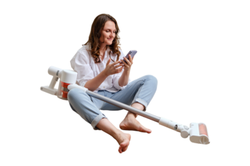 Happy woman with a phone sets up a wireless portable vacuum cleaner sitting on the floor, isolated on a white background. Smiling woman after cleaning the floor in the apartment with a vacuum cleaner