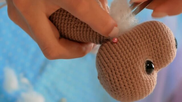 Toy stuffing process, creating special gift. care crafting stuffed toy, thoughtful, handcrafted gift. joy making giving handmade, stuffed toy symbol affection personal touch gift-giving. Vertical